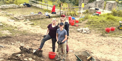 Three Masters students at an archaeological dig